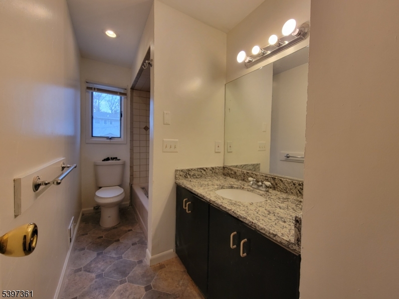 10 Richards Road Hopatcong, NJ 07843 - Photo 17 of 18 a bathroom with a granite countertop sink a toilet a mirror and shower