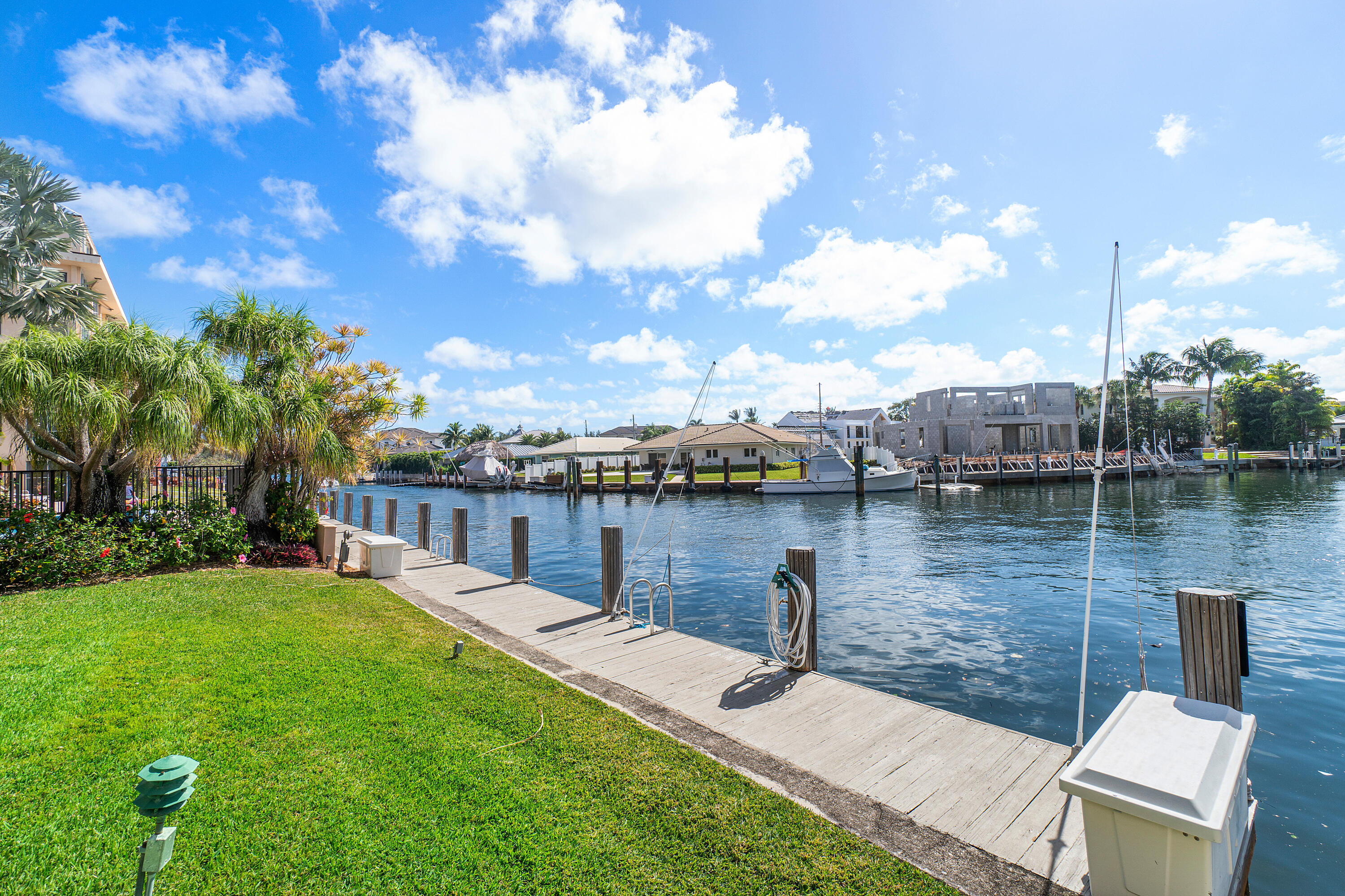 698 Northeast Spanish River Boulevard, Unit 140 Boca Raton, FL 33431 - Photo 14 of 21 a wooden bench sitting next to a lake