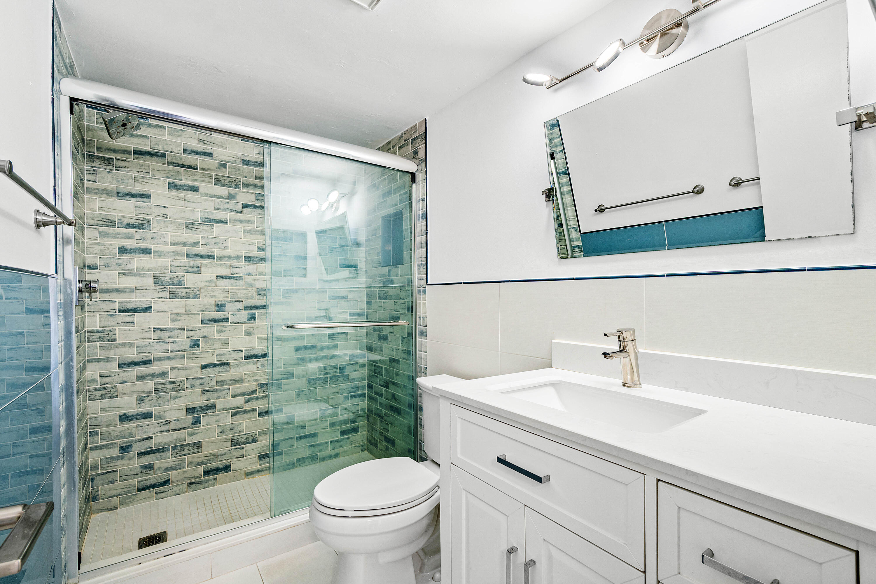 698 Northeast Spanish River Boulevard, Unit 140 Boca Raton, FL 33431 - Photo 9 of 21 a bathroom with a sink a toilet and shower