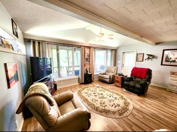 a living room with furniture large window and a flat screen tv