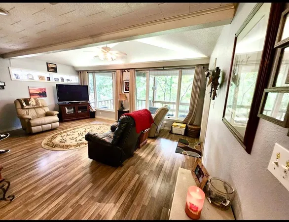 a living room with furniture or chandelier and a wooden floor