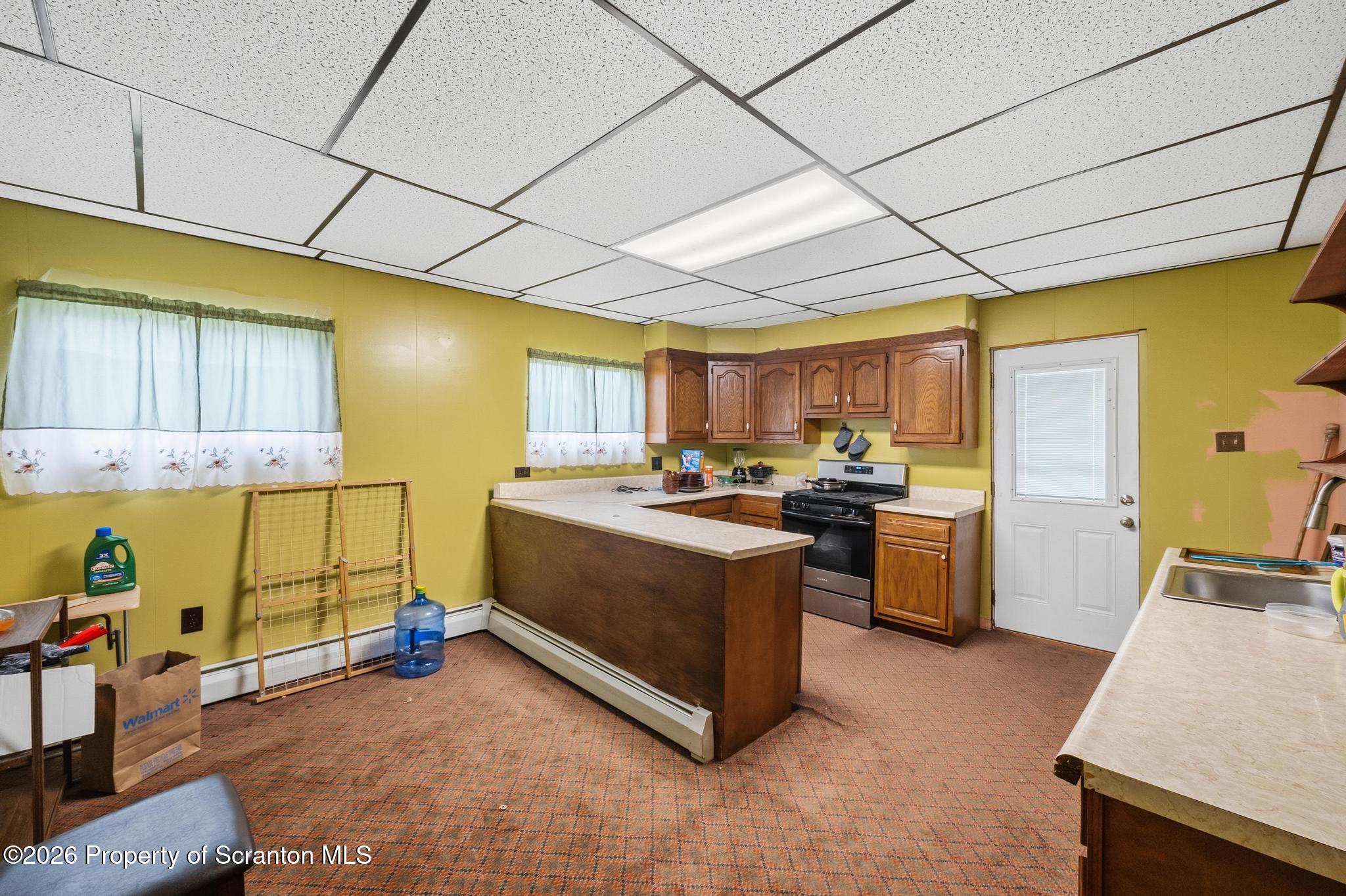 810 Pine Street Mayfield, PA 18433 - Photo 19 of 37 a kitchen with stainless steel appliances granite countertop a sink a stove cabinets counter space and a window