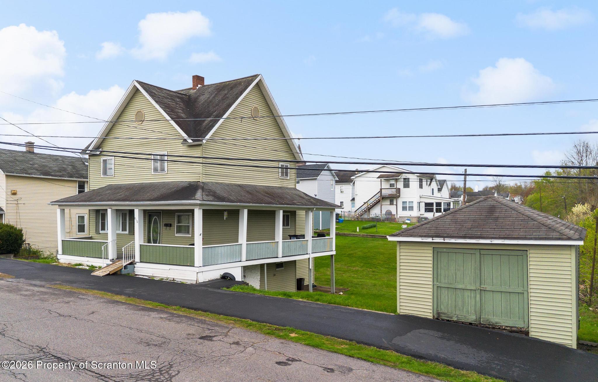 810 Pine Street Mayfield, PA 18433 - Photo 2 of 37 a front view of a house with a garden and garage
