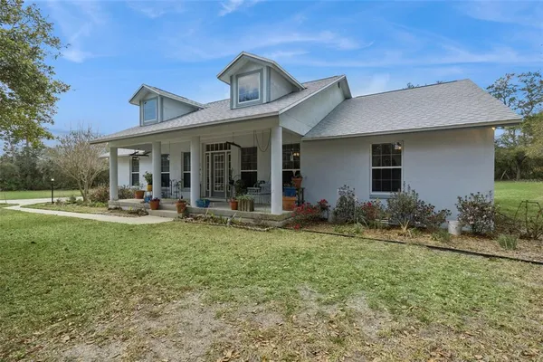 a view of a house with backyard porch and sitting area