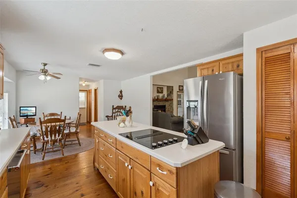 a kitchen with stainless steel appliances granite countertop a stove refrigerator and chairs