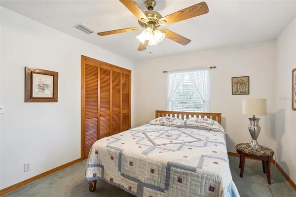a bedroom with a bed and a chair with the wooden floor
