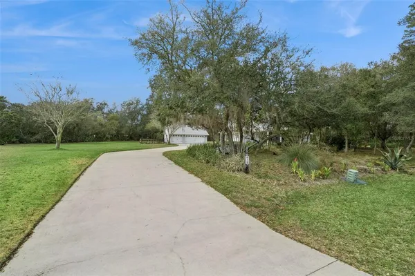 an aerial view of residential houses with outdoor space and trees