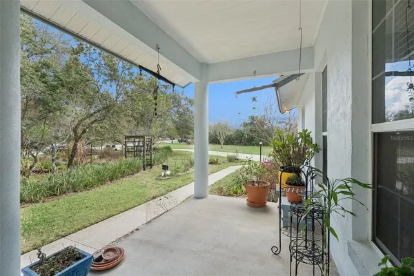 a view of a porch with furniture and garden