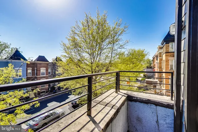 a view of a balcony with wooden floor and outdoor seating