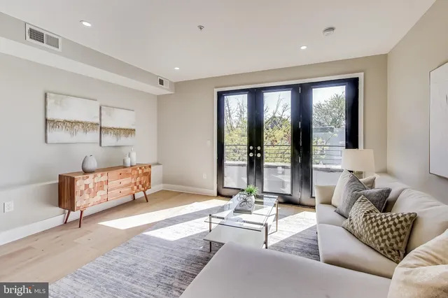 a living room with furniture and large windows