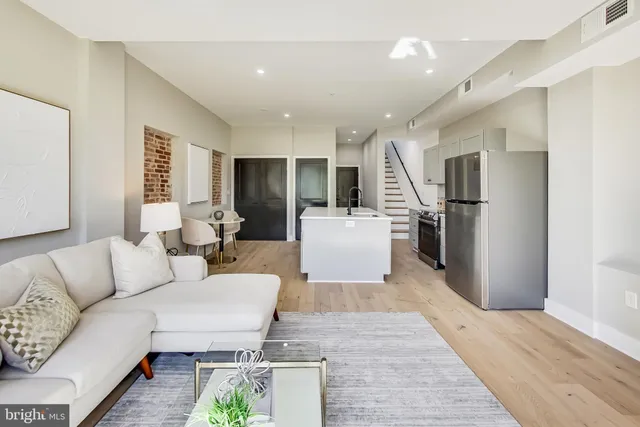 a living room with furniture and kitchen view