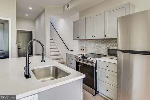 a kitchen with white cabinets and appliances