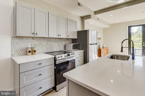 a kitchen with refrigerator a stove a sink dishwasher and cabinets with wooden floor