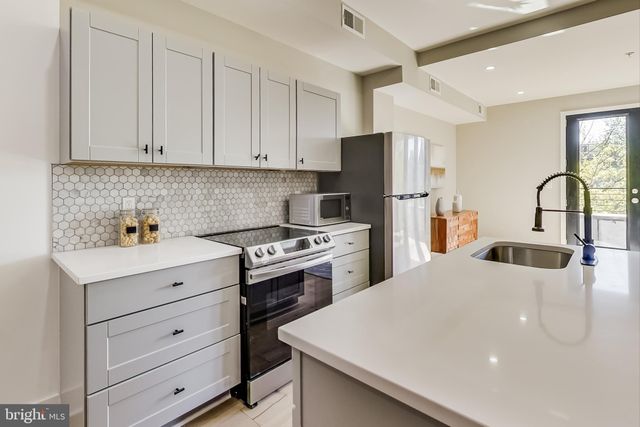 a kitchen with refrigerator a stove a sink dishwasher and cabinets with wooden floor