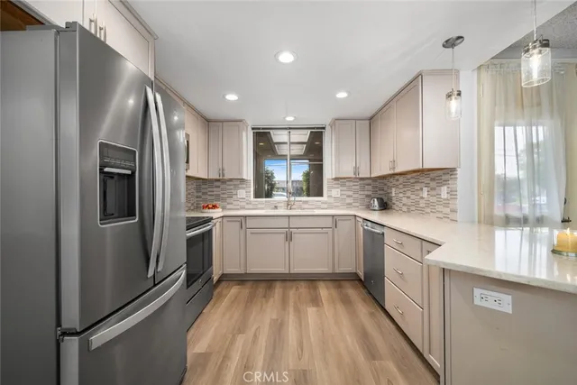 a kitchen with a refrigerator sink and cabinets