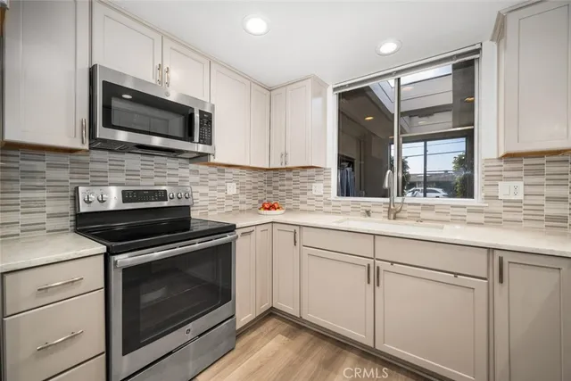 a kitchen with granite countertop white cabinets stainless steel appliances and a sink