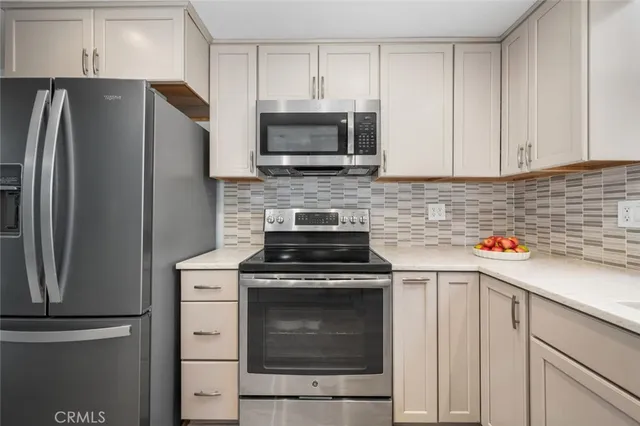 a kitchen with stainless steel appliances white cabinets and a stove