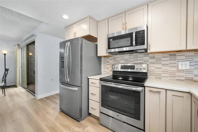 a kitchen with stainless steel appliances a stove a microwave and a hard wood floors