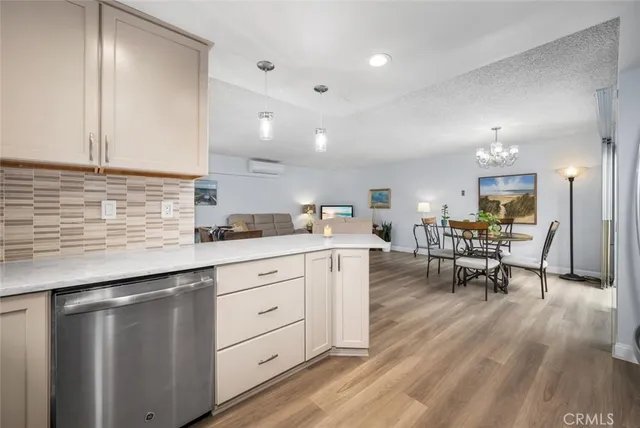 a kitchen with white cabinets sink and chairs
