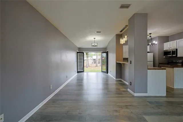 a view of kitchen with refrigerator stove and wooden floor