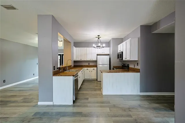a large kitchen with cabinets and stainless steel appliances