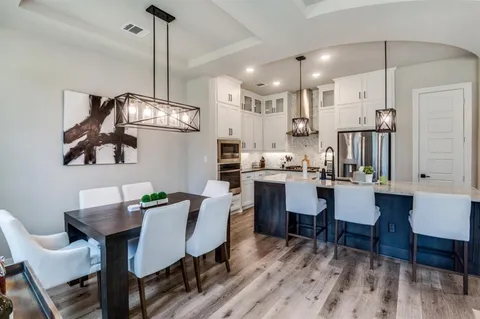 a dining room with furniture a chandelier and wooden floor