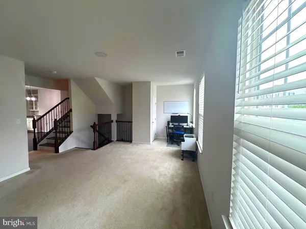 a view of a livingroom with furniture and a hallway