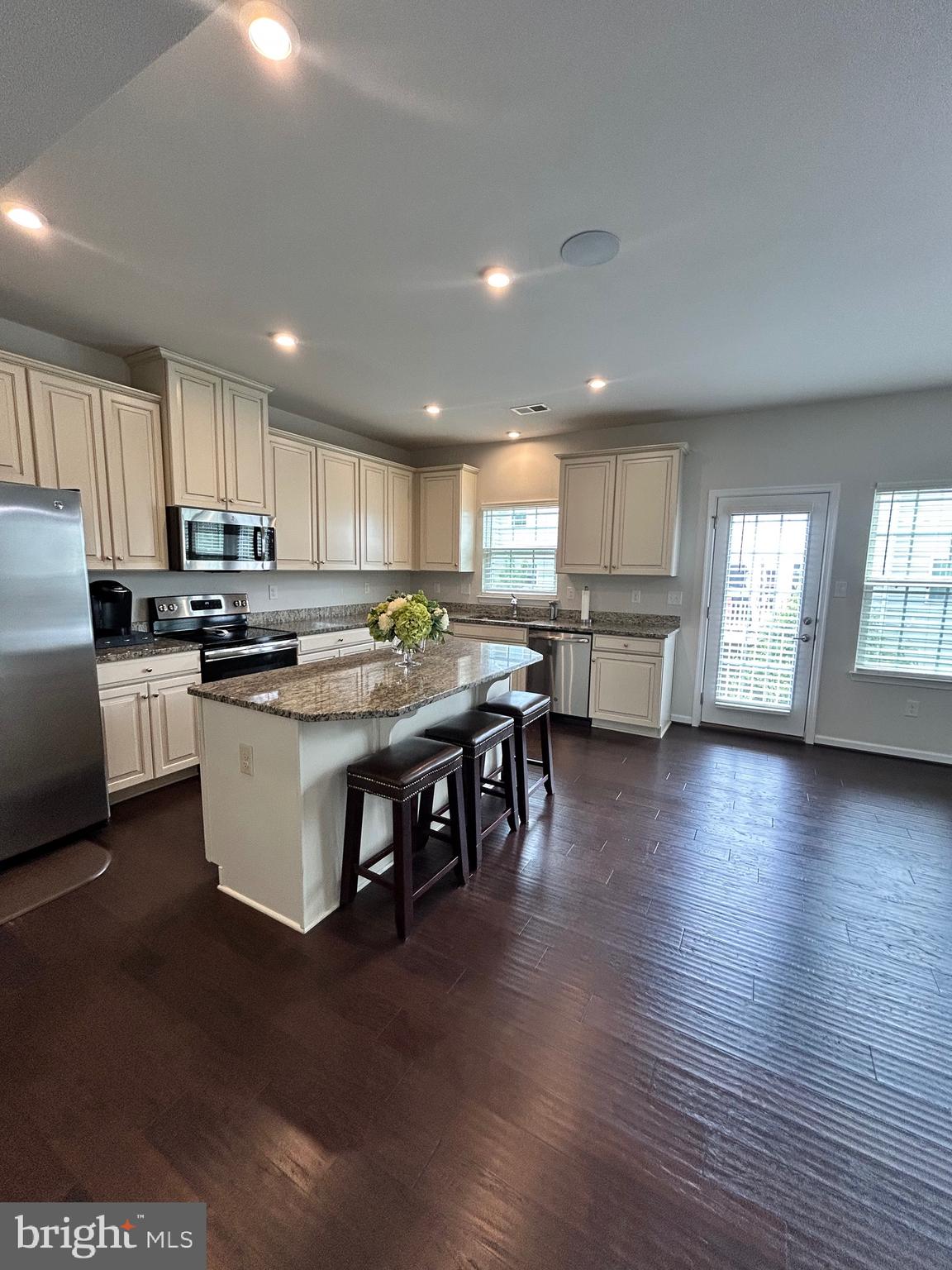 642 Barrie Road Middletown, DE 19709 - Photo 17 of 36 a kitchen with stainless steel appliances granite countertop a stove top oven a sink dishwasher and white cabinets with wooden floor