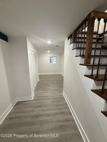 a view of an empty room with wooden floor