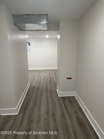 a view of a room with wooden floor and white walls