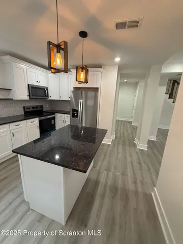 a kitchen with a counter top space a sink and appliances