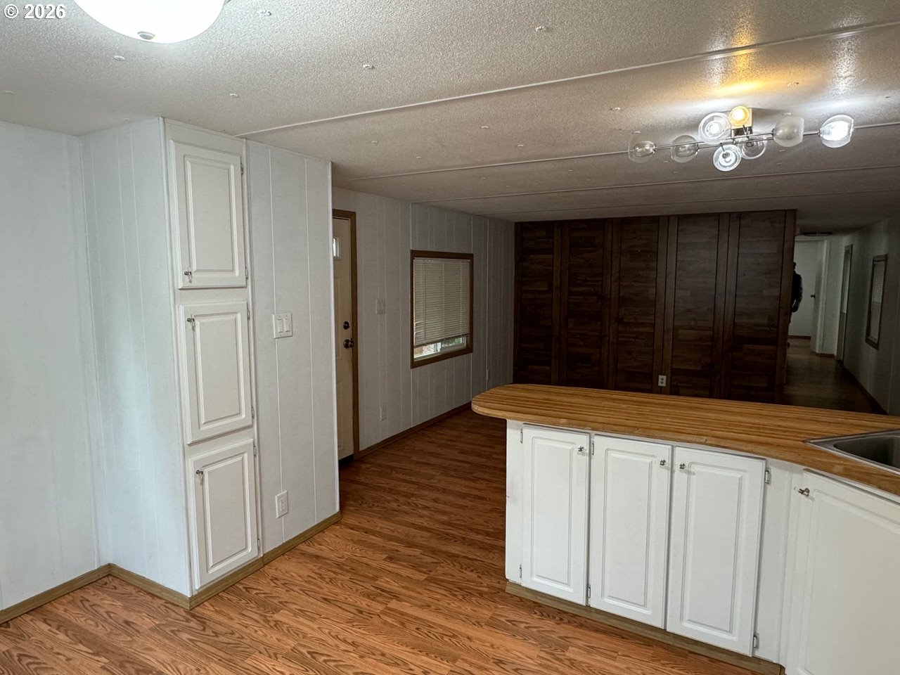 1600 Rhododendron Drive, Unit 293 Florence, OR 97439 - Photo 16 of 26 an empty room with wooden floor and hallway