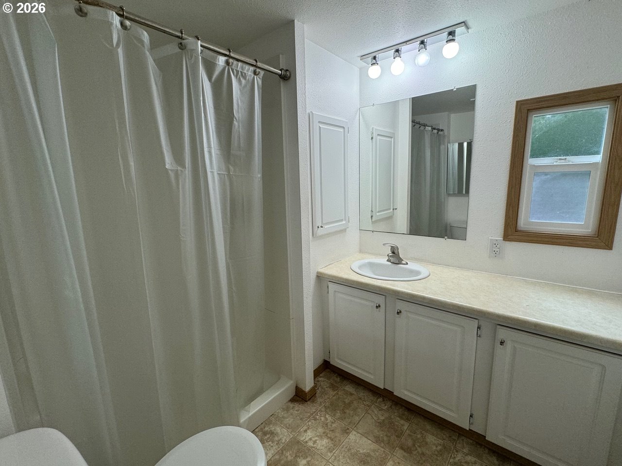 1600 Rhododendron Drive, Unit 293 Florence, OR 97439 - Photo 24 of 26 a bathroom with a double vanity sink and mirror