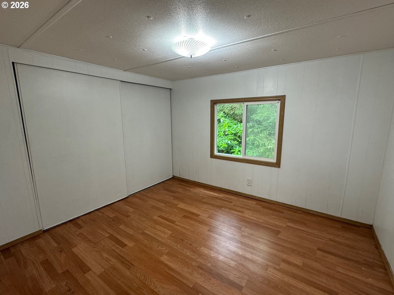 1600 Rhododendron Drive, Unit 293 Florence, OR 97439 - Photo 25 of 26 an empty room with wooden floor and windows