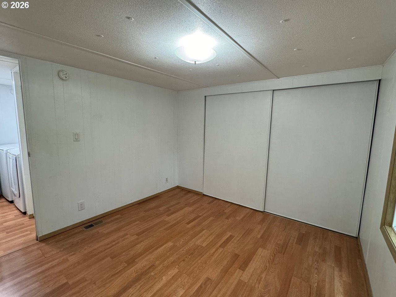 1600 Rhododendron Drive, Unit 293 Florence, OR 97439 - Photo 26 of 26 an empty room with wooden floor and a window