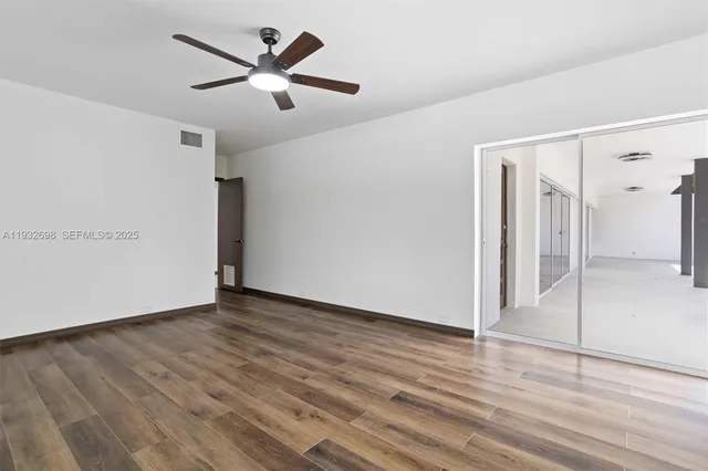 a view of an empty room with wooden floor