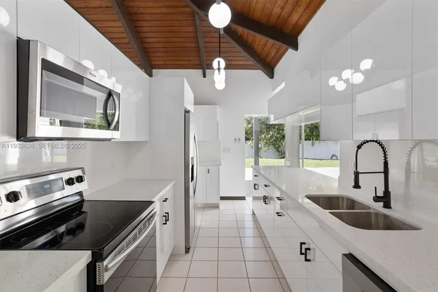 a kitchen with a sink appliances and cabinets