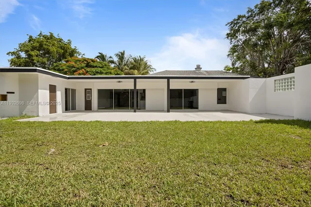 a blue house with a yard in back