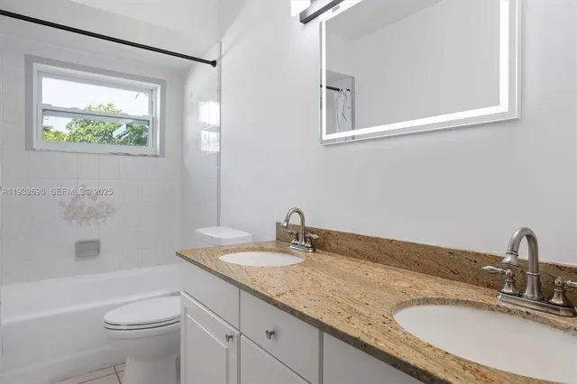 a bathroom with a granite countertop sink a toilet and a bathtub