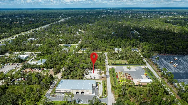 an aerial view of residential houses with outdoor space and trees