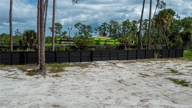 a view of a yard with wooden fence