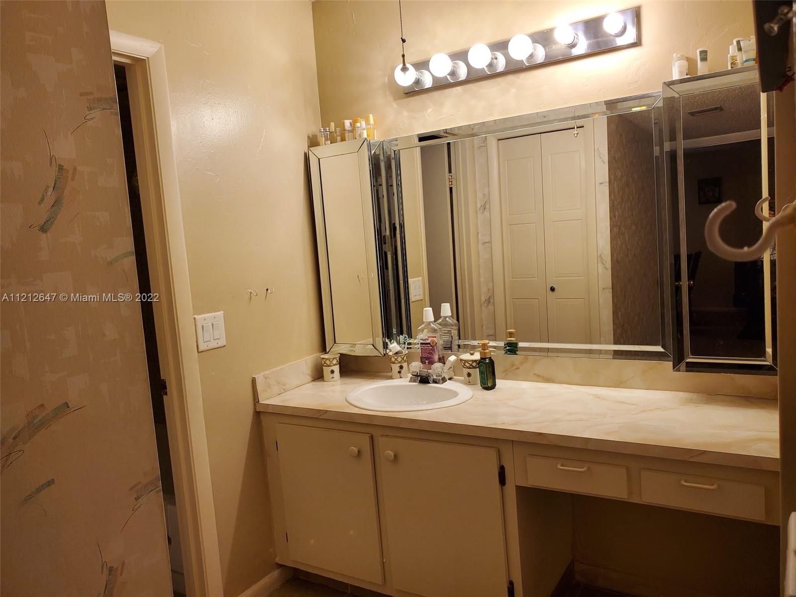 370 Racquet Club Road, Unit 204 Weston, FL 33326 - Photo 6 of 12 a bathroom with a double vanity sink and a mirror
