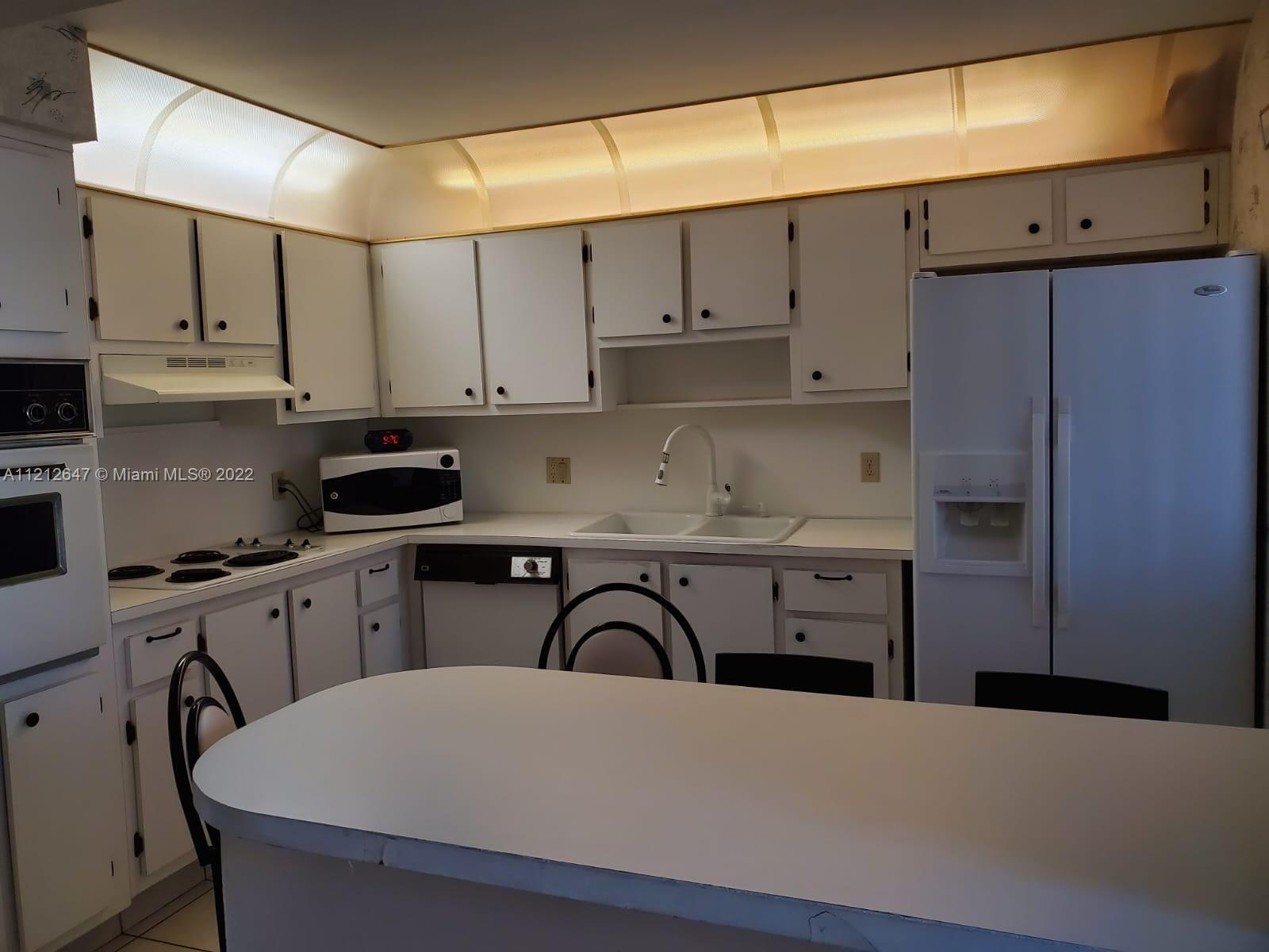 370 Racquet Club Road, Unit 204 Weston, FL 33326 - Photo 9 of 12 a kitchen with stainless steel appliances a sink dishwasher a refrigerator and cabinets with wooden floor