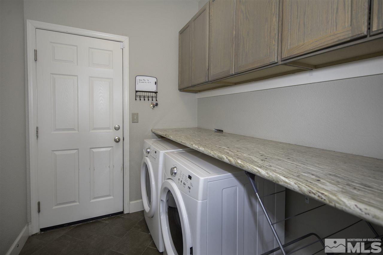 11305 Verazae Drive Reno, NV 89521 - Photo 13 of 25 a utility room with granite countertop cabinets washer and dryer