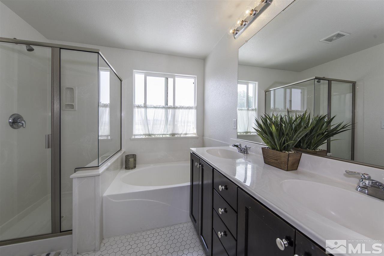 11305 Verazae Drive Reno, NV 89521 - Photo 16 of 25 a bathroom with a granite countertop sink a mirror a vanity and a bathtub