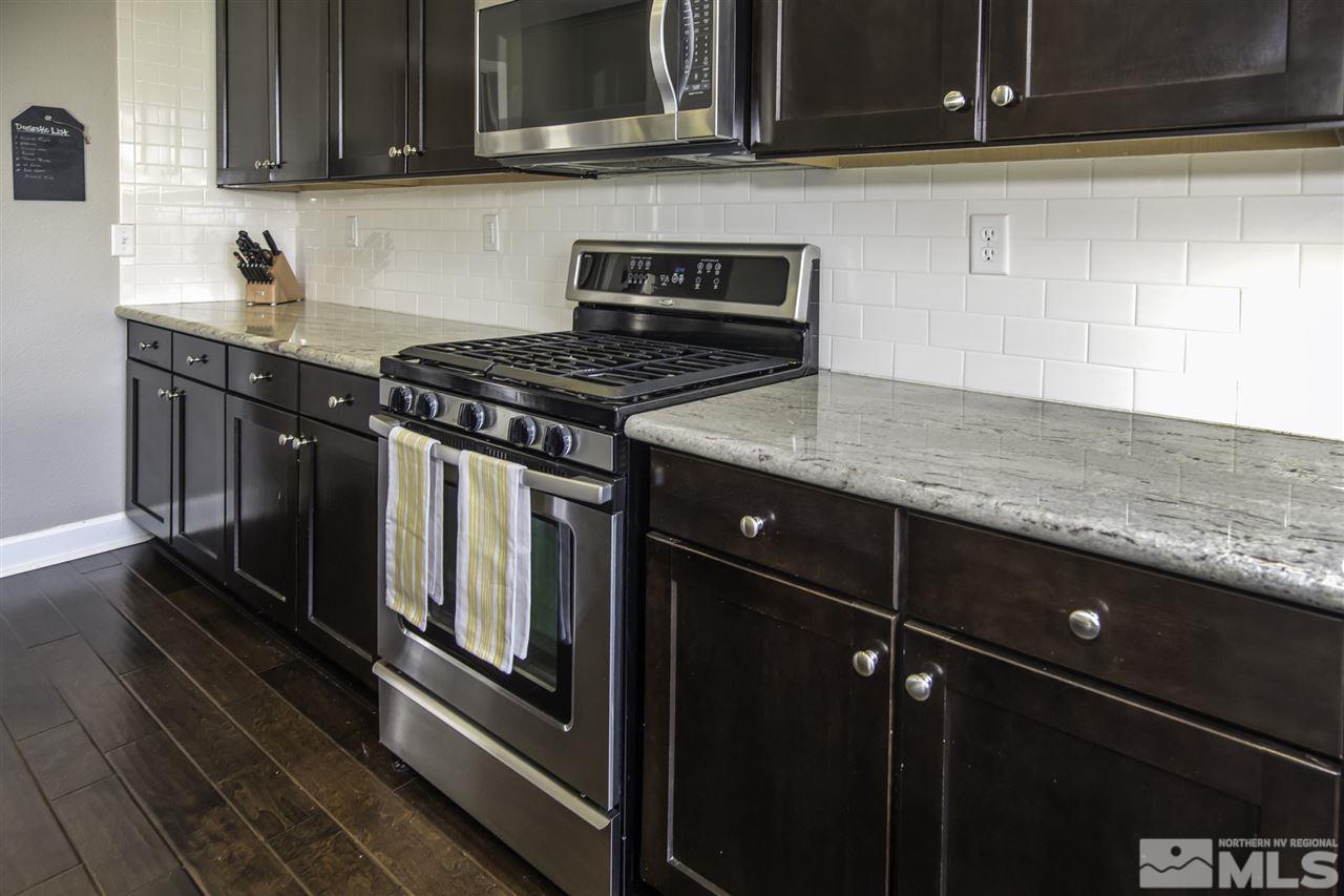 11305 Verazae Drive Reno, NV 89521 - Photo 9 of 25 a kitchen with granite countertop a stove and a sink