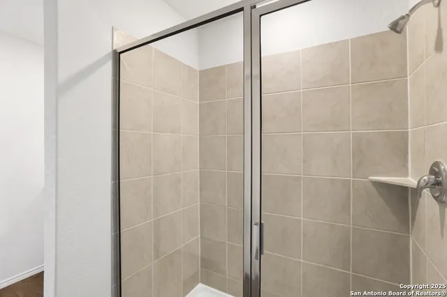a bathroom with a shower and a glass door