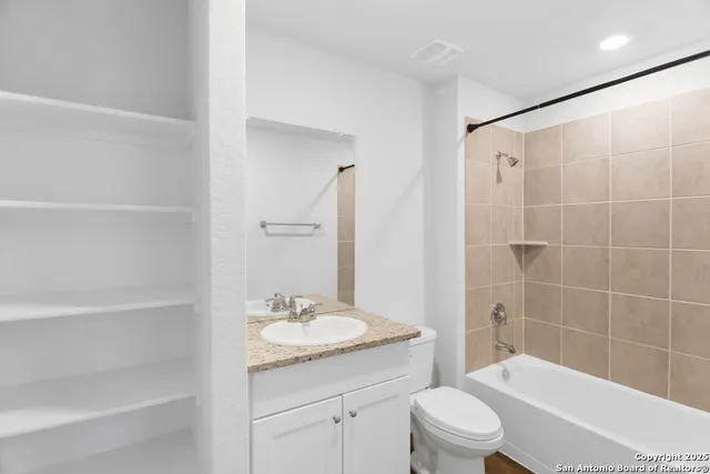 a bathroom with a granite countertop sink a toilet and shower