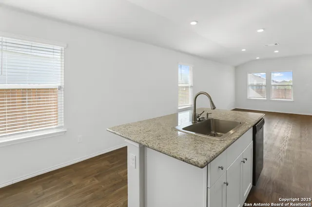 a kitchen with granite countertop a sink and wooden floor