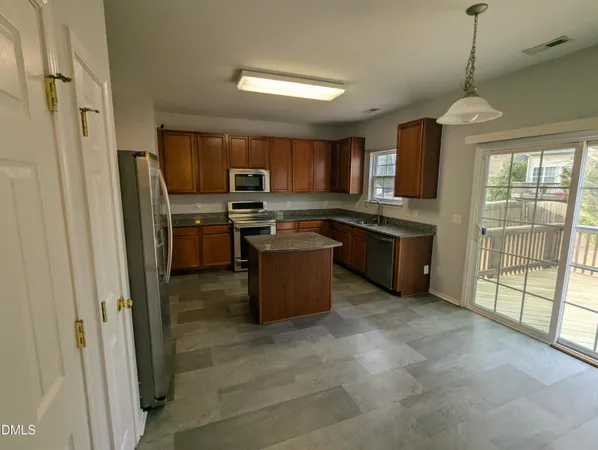 a kitchen with stainless steel appliances granite countertop a refrigerator a sink a stove top oven and a refrigerator